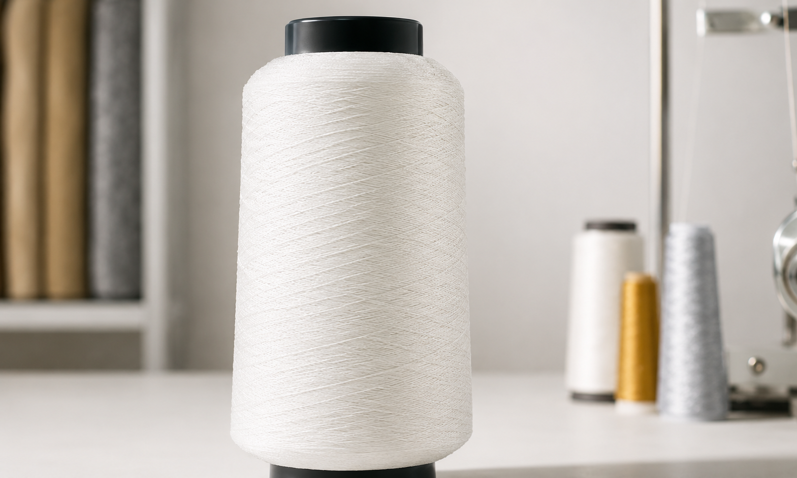 Gold metallic yarn cone on a workshop counter with twisting equipment